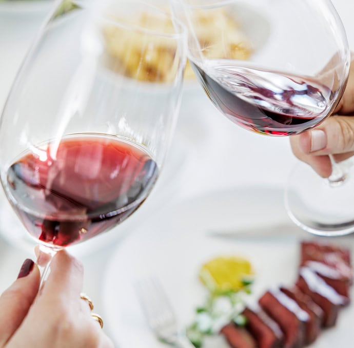 Steersons: Cheers with wine in front of sliced steak