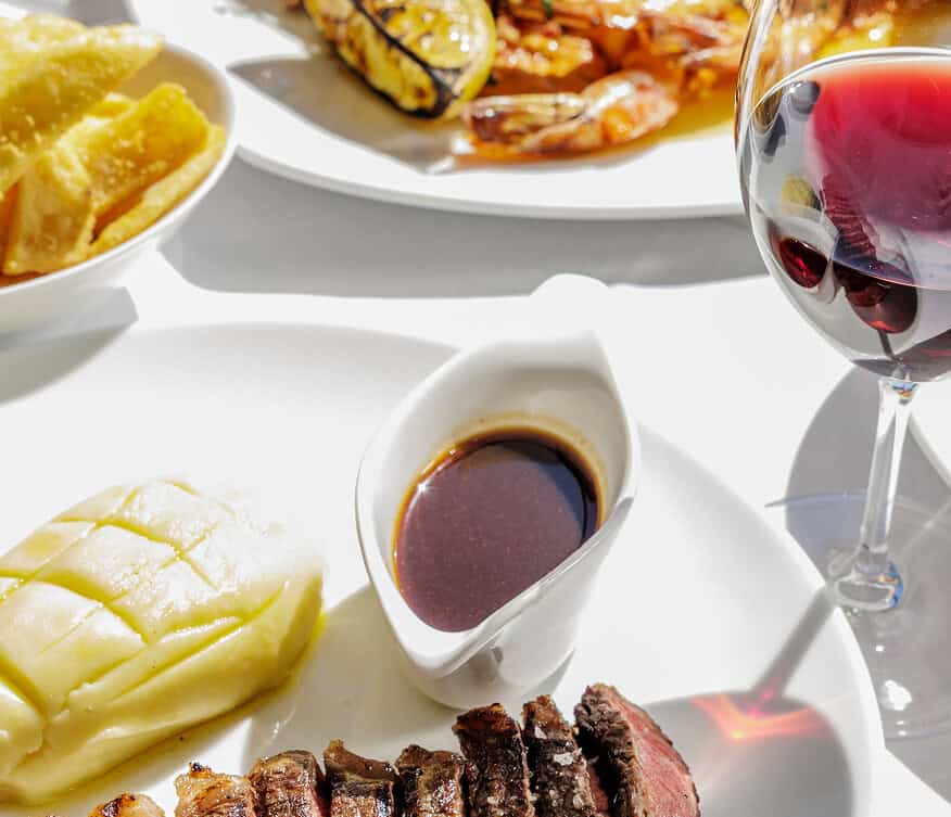 Steersons: Dining table with wine, chips, steak and sides